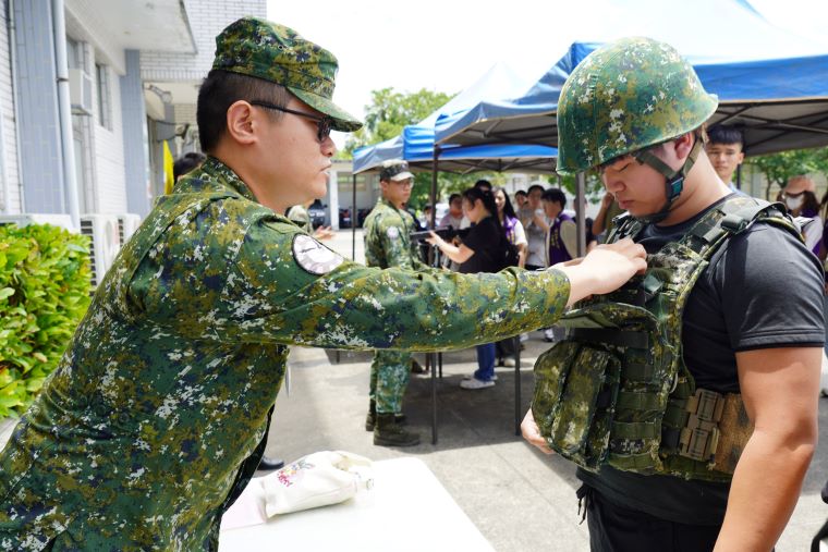 《圖說》參訪空軍憲兵中隊，青年體驗穿放防彈衣。〈社會局提供〉二