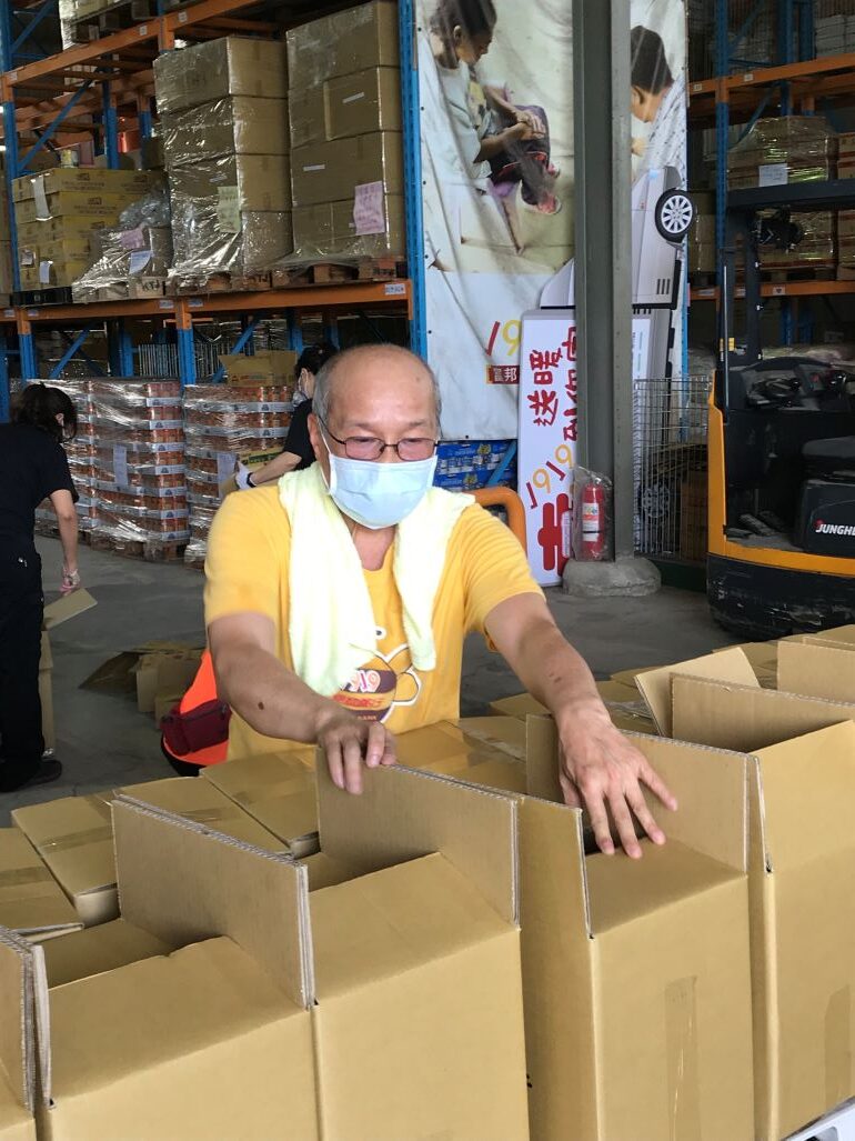 《圖說》邱大信到1919食物銀行八里倉庫幫忙整理食物箱  以寄送給弱勢案家。〈社會局提供〉